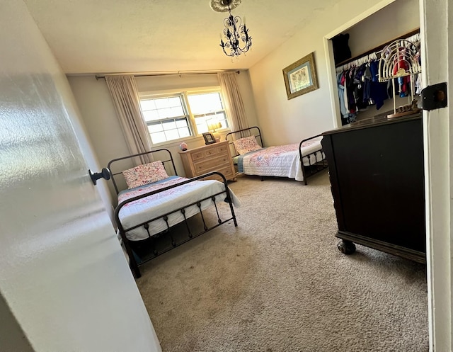 carpeted bedroom with a chandelier and a closet