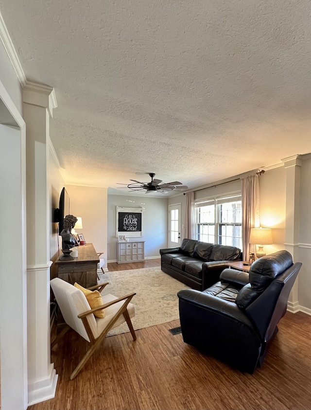 living room featuring hardwood / wood-style flooring, ceiling fan, crown molding, and a textured ceiling