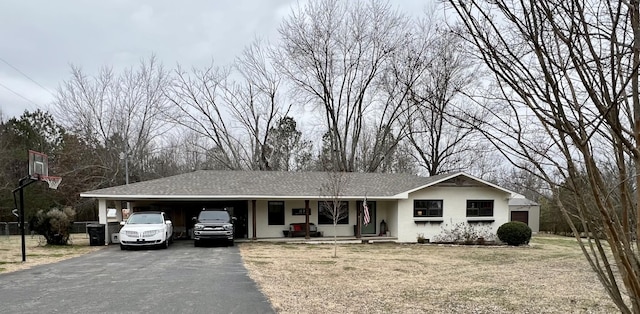 ranch-style home featuring a carport and a front lawn