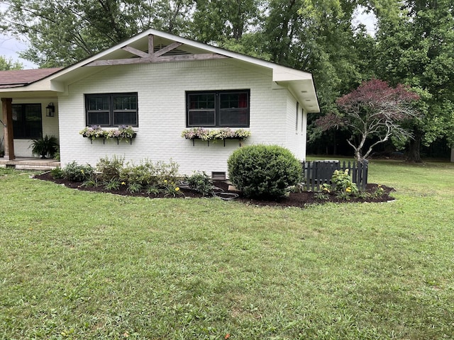 view of side of home with a lawn