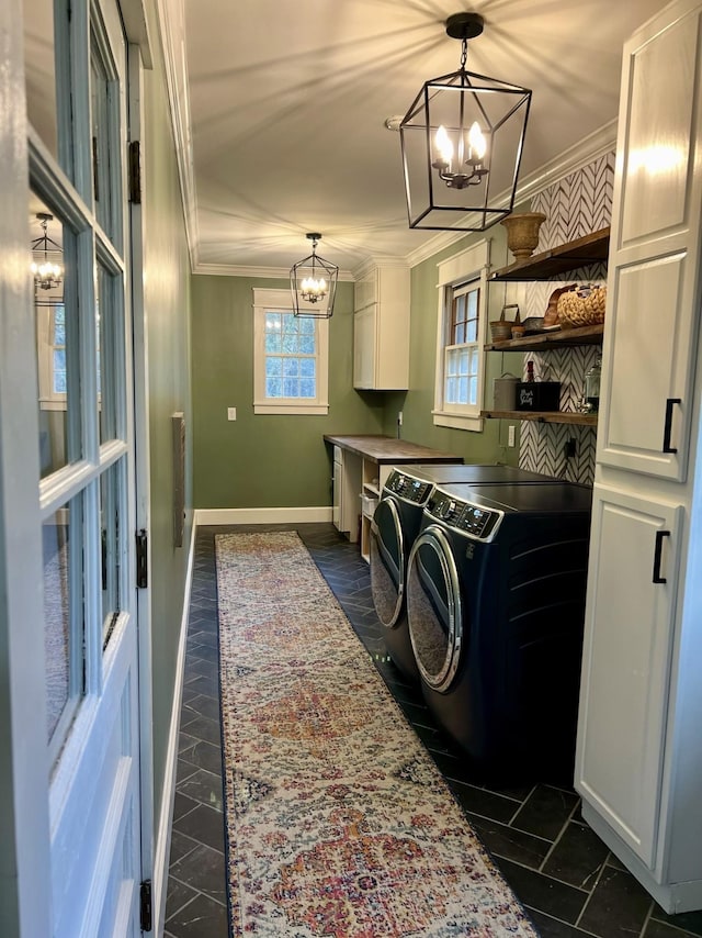 laundry room with cabinets, crown molding, washing machine and clothes dryer, and a chandelier