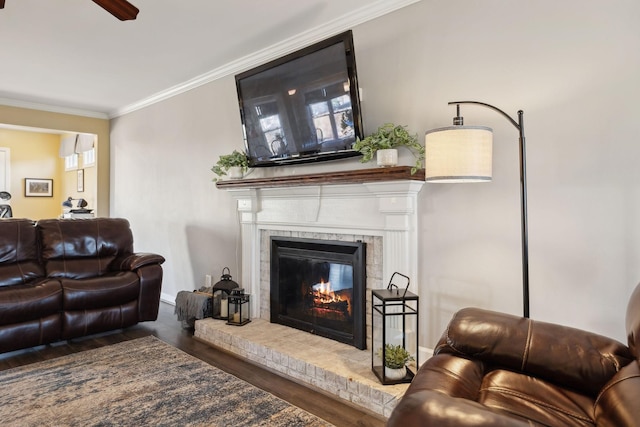 living room with ornamental molding, hardwood / wood-style floors, and a brick fireplace