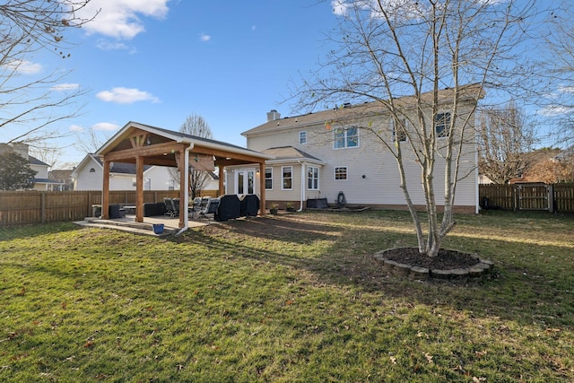 back of house with a yard and a patio