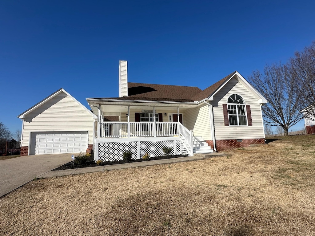 ranch-style house featuring a garage, covered porch, and a front lawn