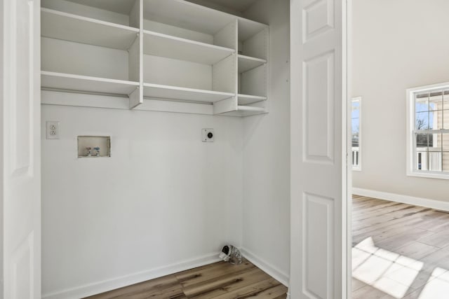 laundry room with hookup for a washing machine, hookup for an electric dryer, laundry area, wood finished floors, and baseboards