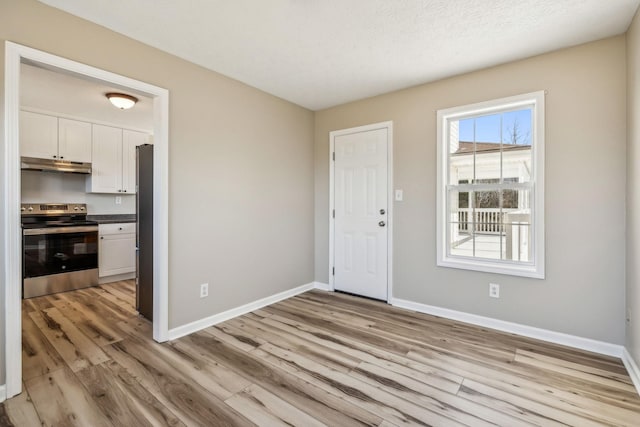 foyer with light wood-style flooring and baseboards