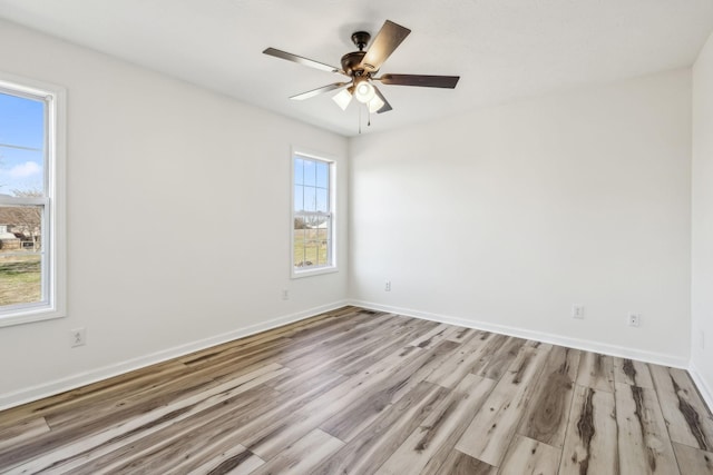 spare room featuring a ceiling fan, baseboards, and wood finished floors