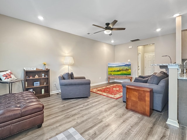 living room with ceiling fan and light wood-type flooring