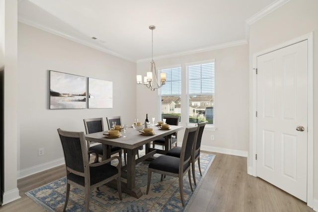 dining room featuring crown molding, a chandelier, and light hardwood / wood-style flooring