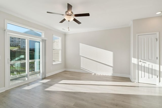 unfurnished room with ornamental molding, ceiling fan, and light wood-type flooring