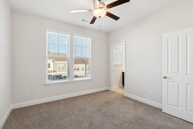 unfurnished room with light colored carpet and ceiling fan