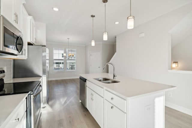 kitchen featuring stainless steel appliances, sink, a kitchen island with sink, and white cabinets