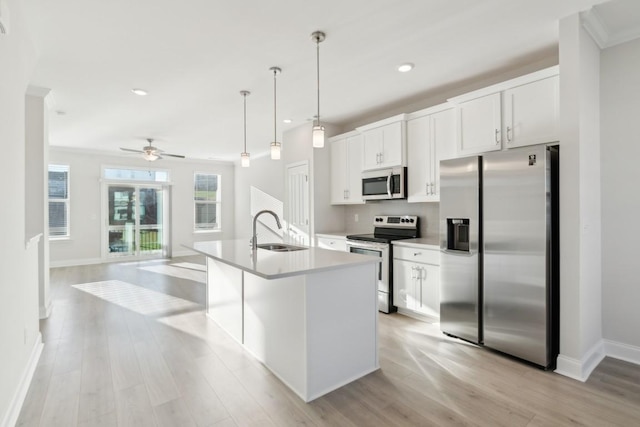 kitchen featuring white cabinetry, stainless steel appliances, sink, and a center island with sink