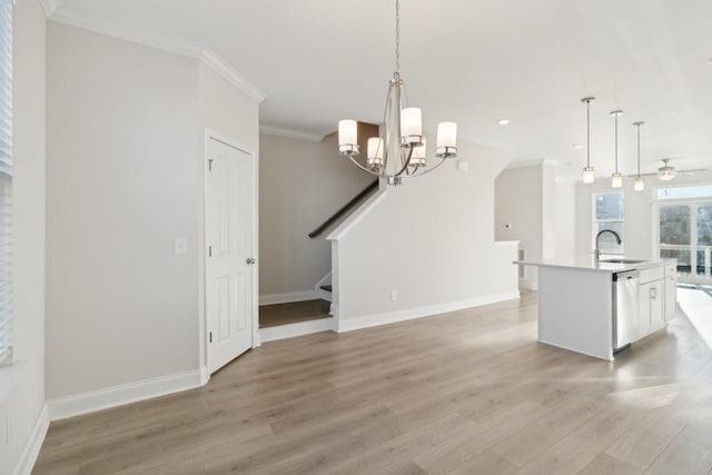 kitchen with ceiling fan with notable chandelier, dishwasher, sink, ornamental molding, and light hardwood / wood-style flooring