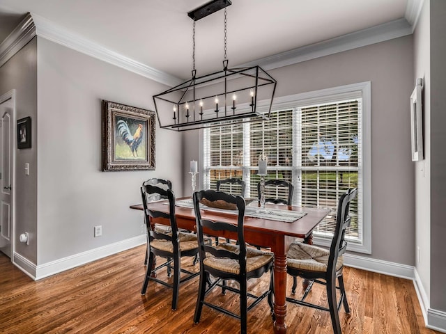 dining space with wood-type flooring and ornamental molding