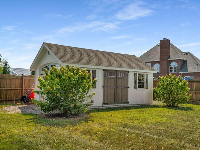 back of house with a storage shed and a yard