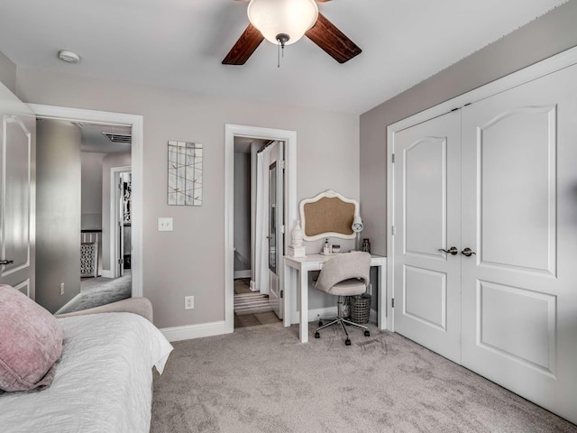 carpeted bedroom with ensuite bathroom, ceiling fan, and a closet