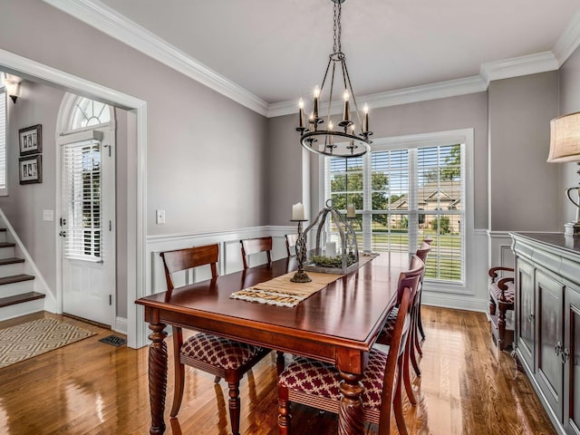 dining area featuring hardwood / wood-style flooring, ornamental molding, and a chandelier