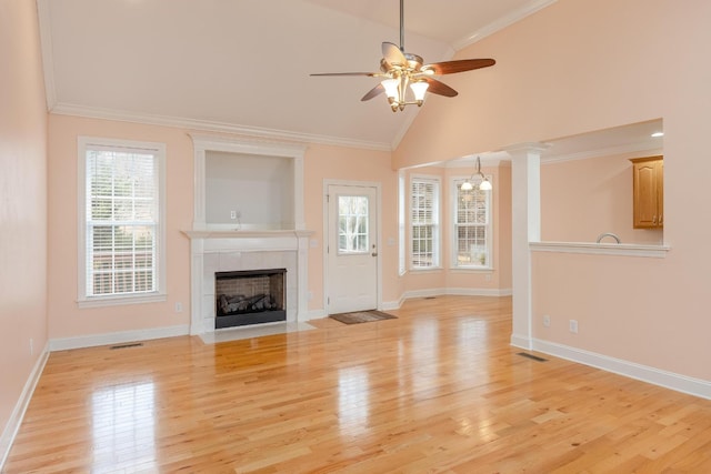 unfurnished living room with decorative columns, ornamental molding, ceiling fan, and light hardwood / wood-style floors