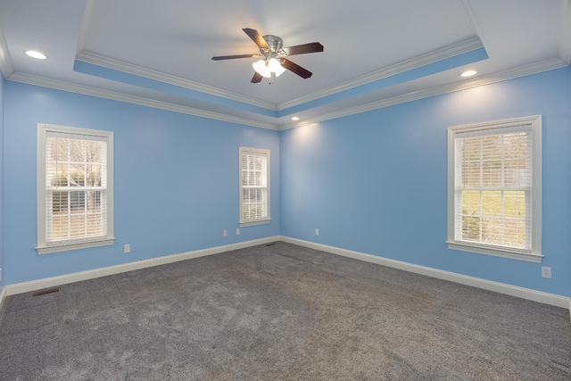 carpeted empty room with a tray ceiling, ornamental molding, and ceiling fan