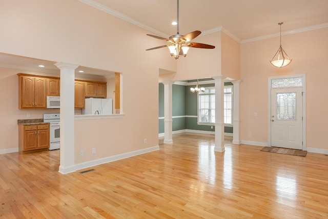 unfurnished living room with crown molding, light hardwood / wood-style floors, a high ceiling, and ornate columns