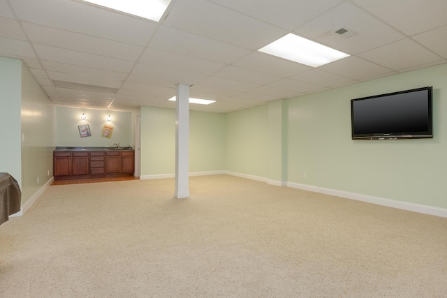 basement with sink, light carpet, and a drop ceiling