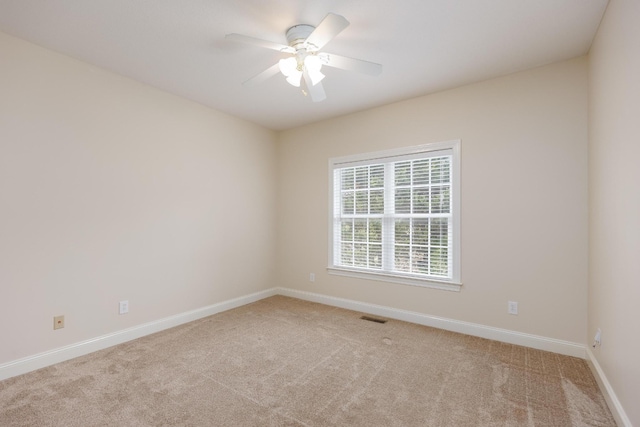 spare room featuring ceiling fan and light colored carpet