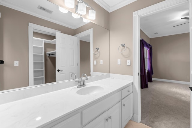 bathroom with visible vents, baseboards, vanity, and crown molding