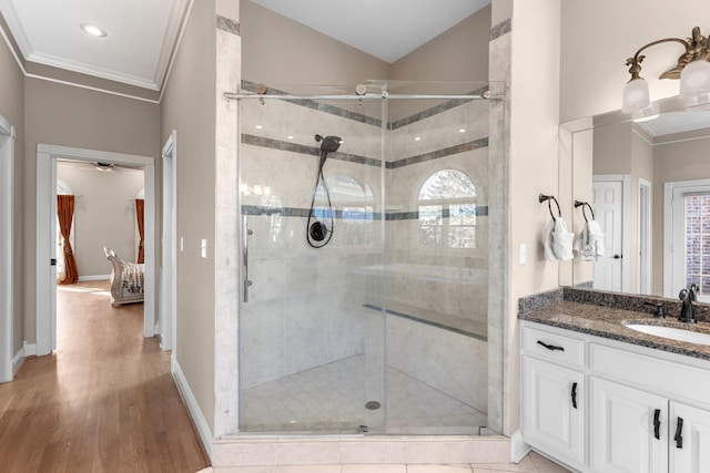 bathroom featuring wood finished floors, vanity, a stall shower, and crown molding