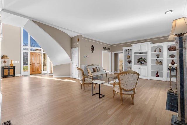 sitting room with visible vents, baseboards, ornamental molding, and light wood finished floors