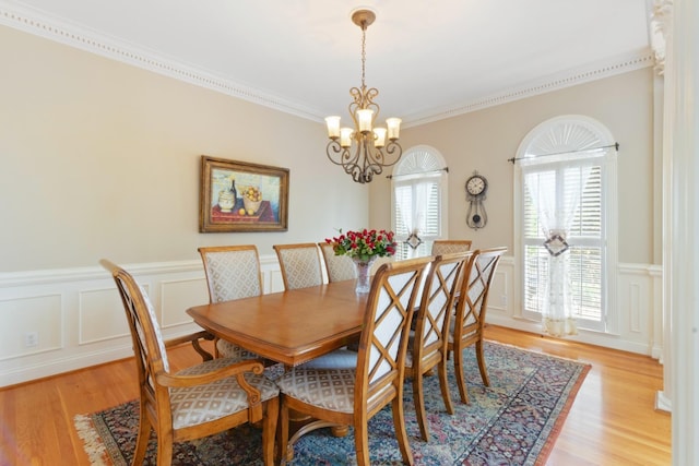 dining room with a wealth of natural light, a chandelier, light wood-style flooring, and crown molding