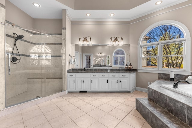 bathroom with a stall shower, vanity, a garden tub, and ornamental molding