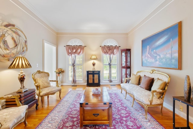 living room with crown molding, baseboards, and wood finished floors