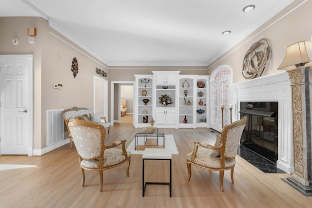 living room with visible vents, baseboards, ornamental molding, a fireplace, and light wood-style floors