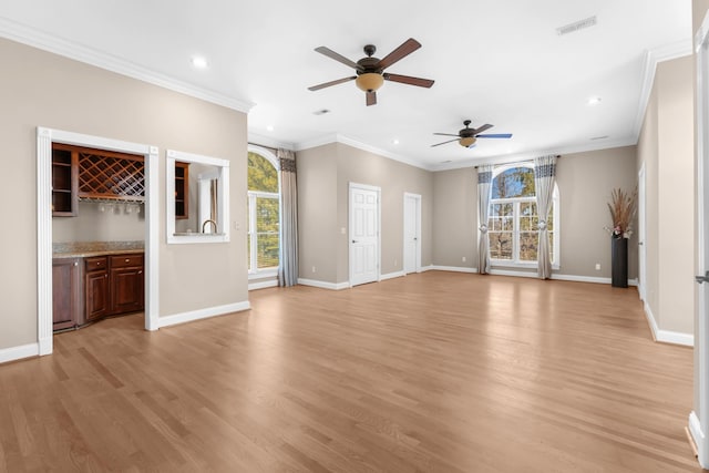 unfurnished living room featuring baseboards, crown molding, and light wood finished floors