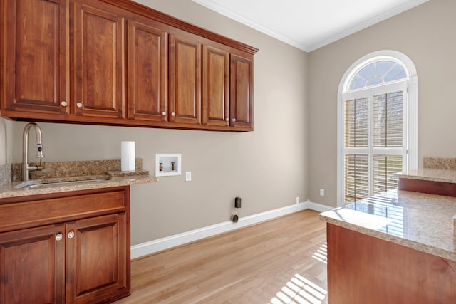 laundry area featuring a sink, a wealth of natural light, hookup for a washing machine, and cabinet space