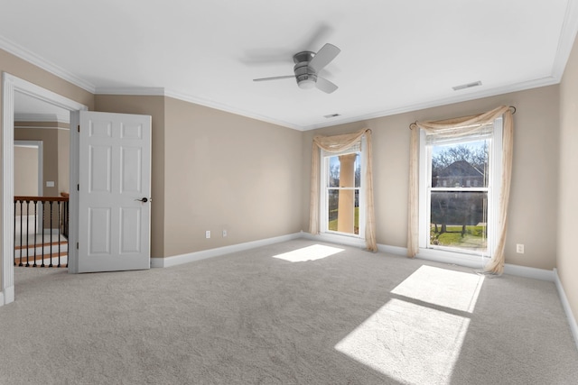 empty room featuring baseboards, visible vents, and ornamental molding