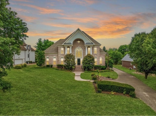 view of front of house with a front yard, a garage, and brick siding