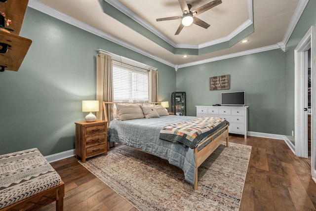 bedroom with a tray ceiling, dark wood-type flooring, ornamental molding, and ceiling fan