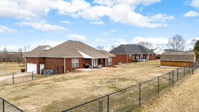 rear view of house featuring a garage, a yard, a patio area, and an outdoor fire pit