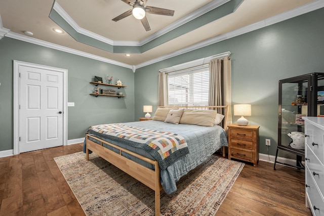 bedroom featuring crown molding, ceiling fan, dark hardwood / wood-style flooring, and a tray ceiling