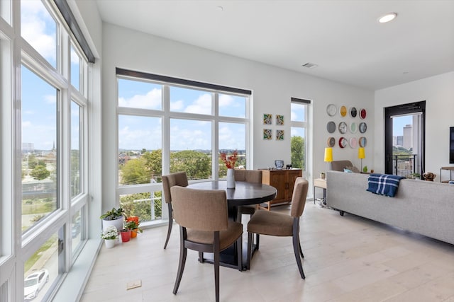 dining area with light hardwood / wood-style floors and a wealth of natural light