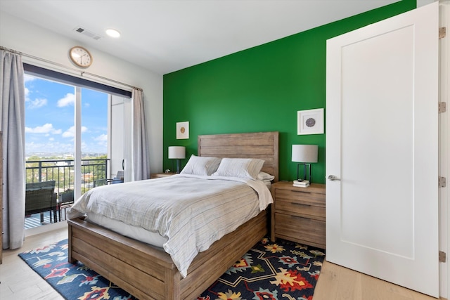 bedroom with access to exterior and light wood-type flooring