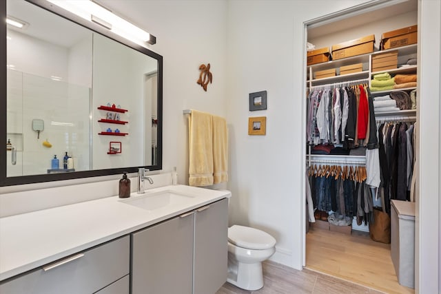 bathroom featuring vanity, an enclosed shower, hardwood / wood-style flooring, and toilet