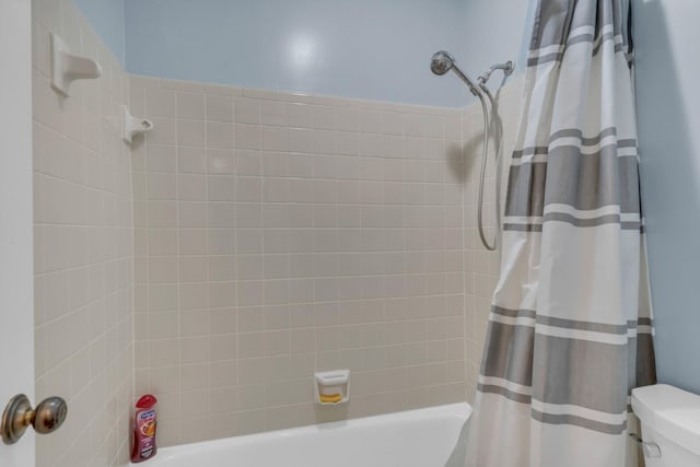 bathroom with shower / tub combo and toilet