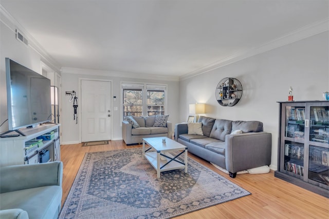 living room featuring crown molding and light hardwood / wood-style floors