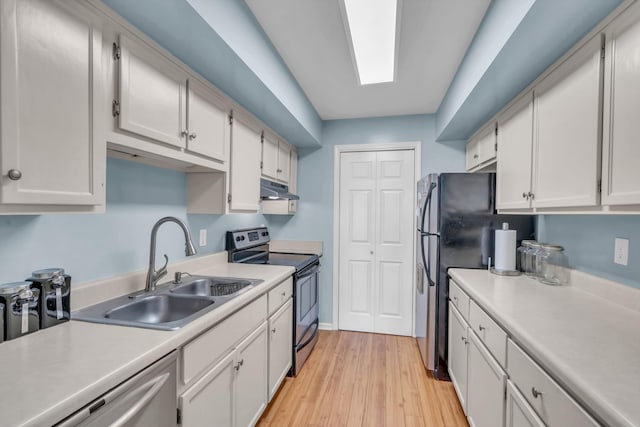 kitchen with appliances with stainless steel finishes, sink, light hardwood / wood-style flooring, and white cabinets