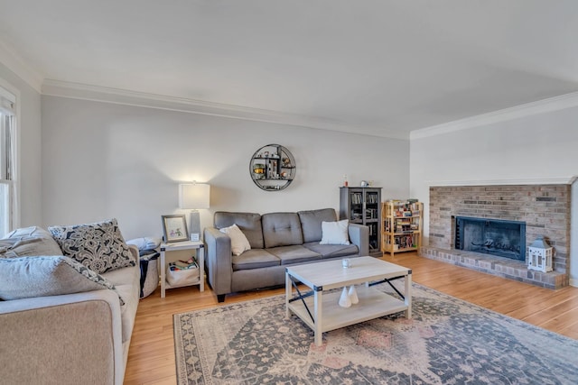 living room with crown molding, a brick fireplace, and light hardwood / wood-style flooring