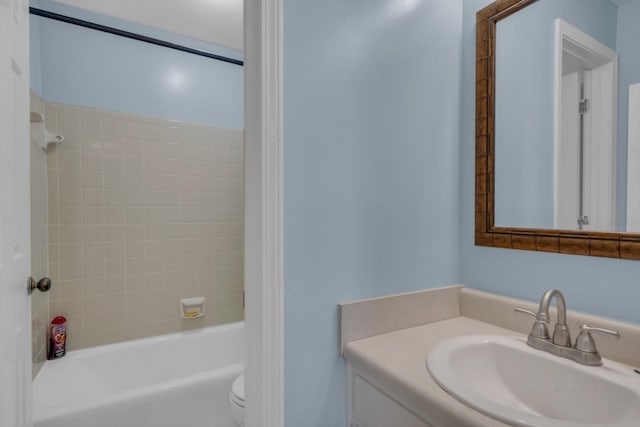 full bathroom featuring vanity, tiled shower / bath combo, and toilet