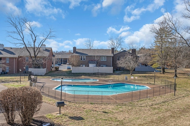 view of pool with a jacuzzi and a lawn